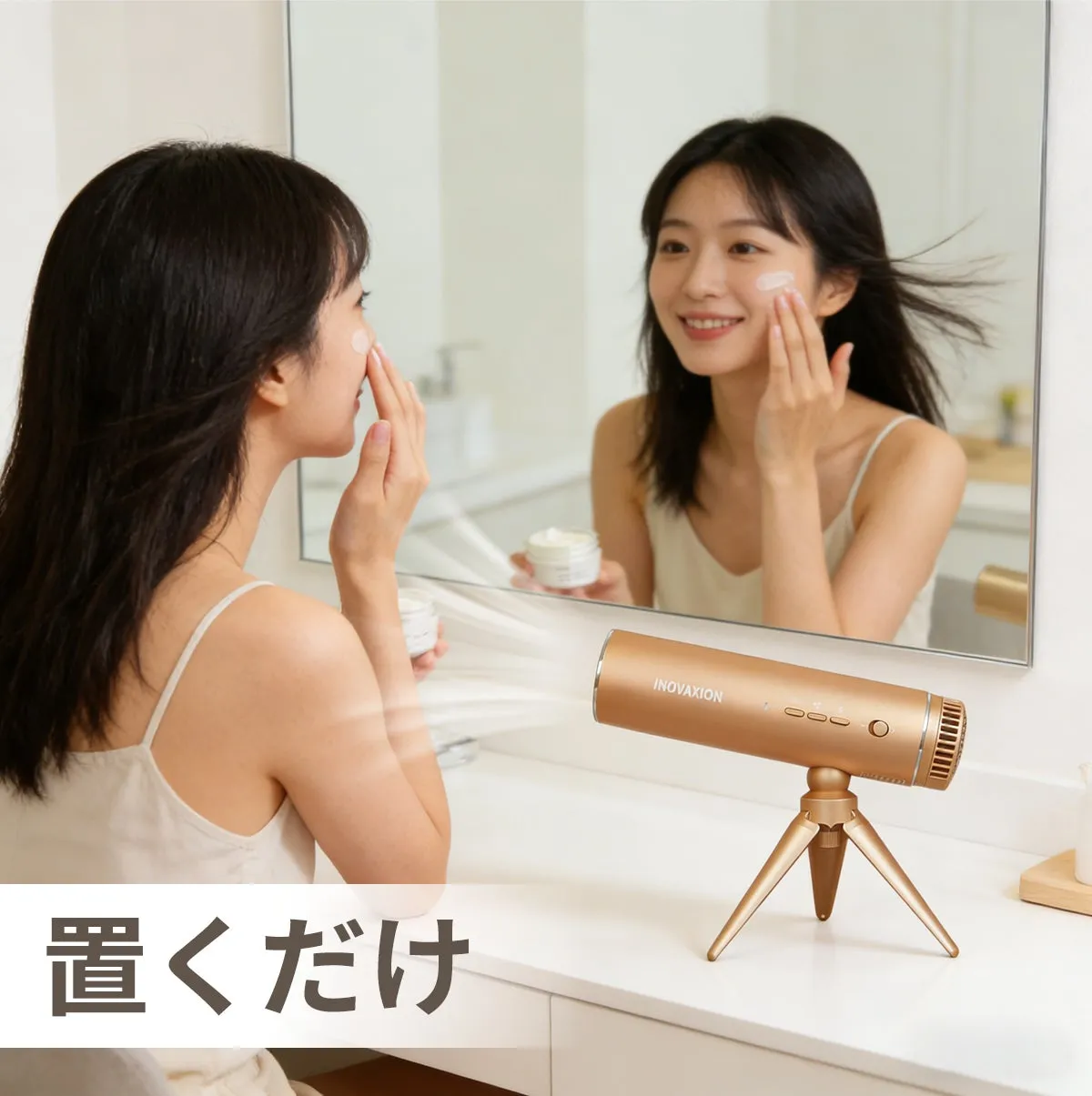 スキンケアをしながらヘアドライをする女性