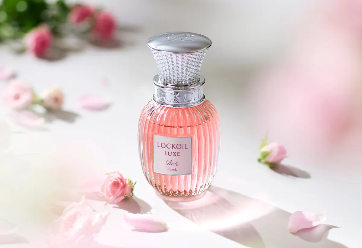 ピンクのバラの花びらに囲まれたReFa LOCK OIL LUXEのボトル
