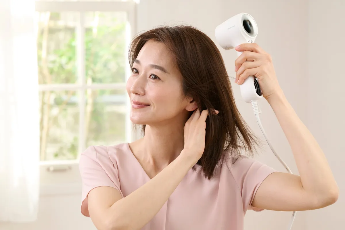 ドライヤーを使用する女性の様子