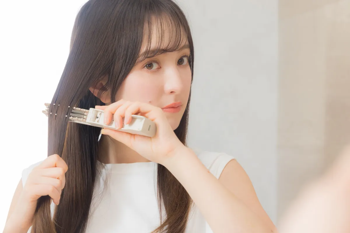 ヒートブラシを使ってスタイリングする女性