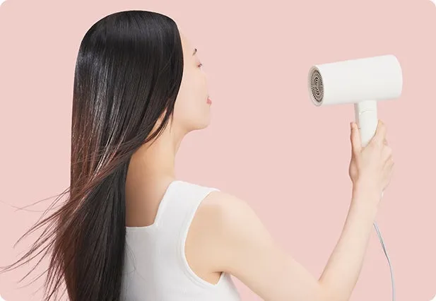 ドライヤーで髪を乾かす女性の様子